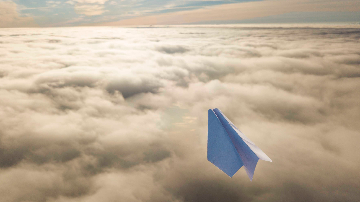 Paper plane above clouds